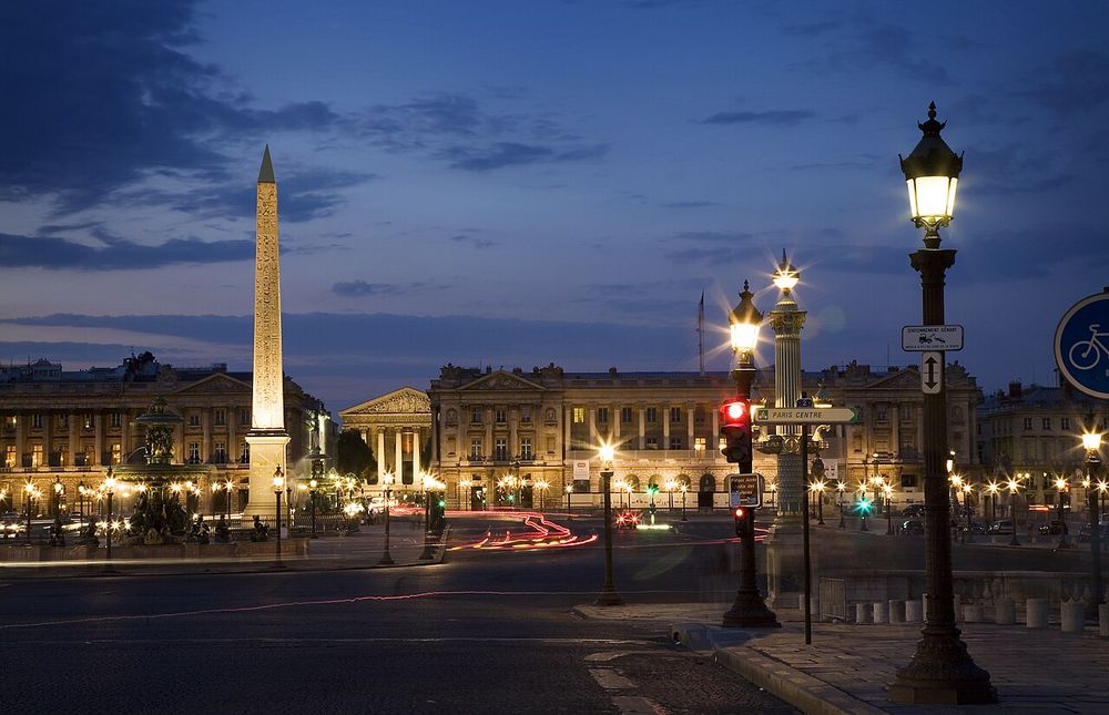 The Place de la Concorde in Paris at dusk, the obelisk and the street lamps lit