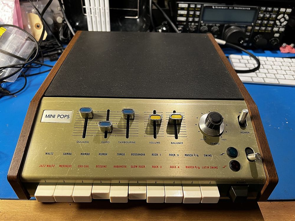 A Korg Mini-Pops 7 rhythm machine, its key-shaped buttons labelled with rhythms such as RUMBA, BOSSANOVA, SLOW ROCK and SWING