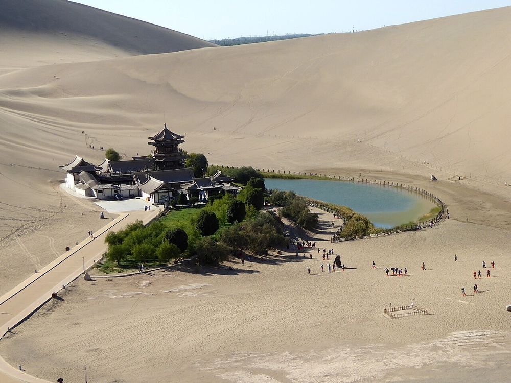 The crescent-shaped spring of Yueyaquan and its pavilion, set among the Mingsha dunes near Dunhuang