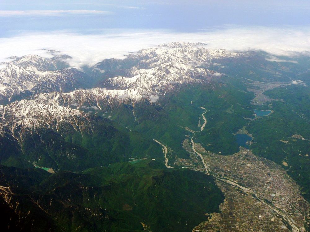 The Omachi basin in Nagano and the Northern Alps seen from the air, with cloud lying beyond the snow-covered ridges