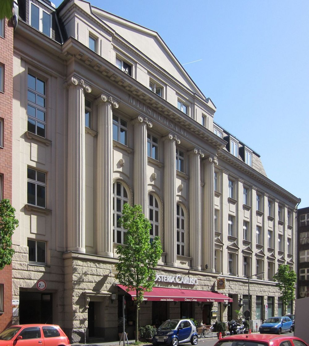 The building at Köthener Straße 38 in Berlin-Kreuzberg, a stone front lined with columns above a red awning