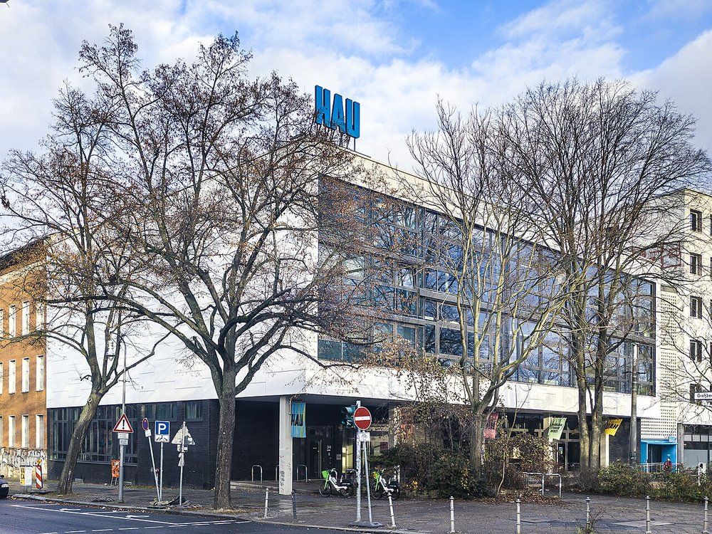 The theatre building on Hallesches Ufer in Berlin-Kreuzberg, a blue HAU sign on the roof and bare trees in front