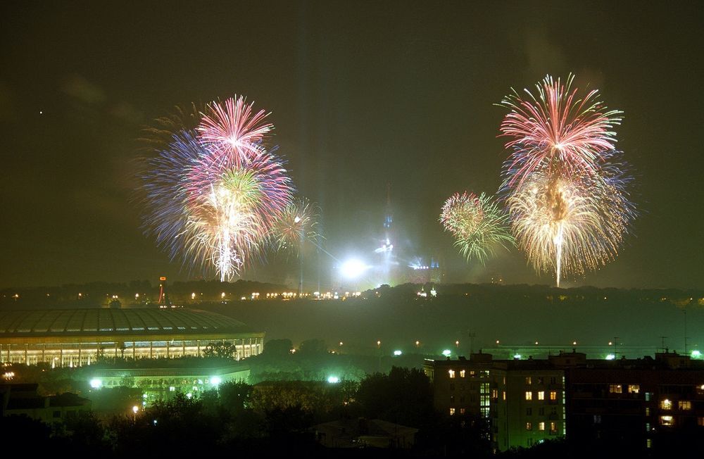 Jean-Michel Jarre's concert on the Sparrow Hills, Moscow, September 1997. Fireworks burst in the night sky above a stadium roof and lit apartment windows